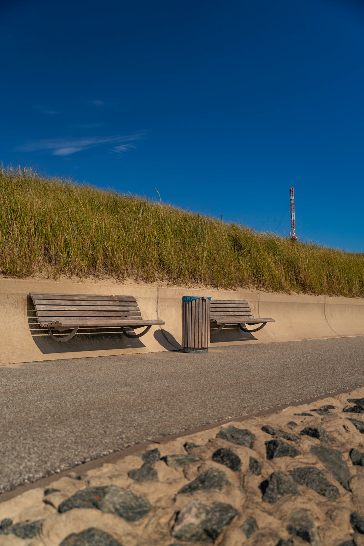 Zwei Bänke an der Borkumer Promenade vor Dünen und blauem Himmel